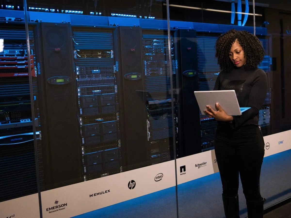Engineer with a laptop monitoring servers in a data centre