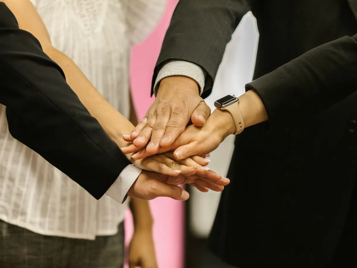Colleagues joining hands as a team