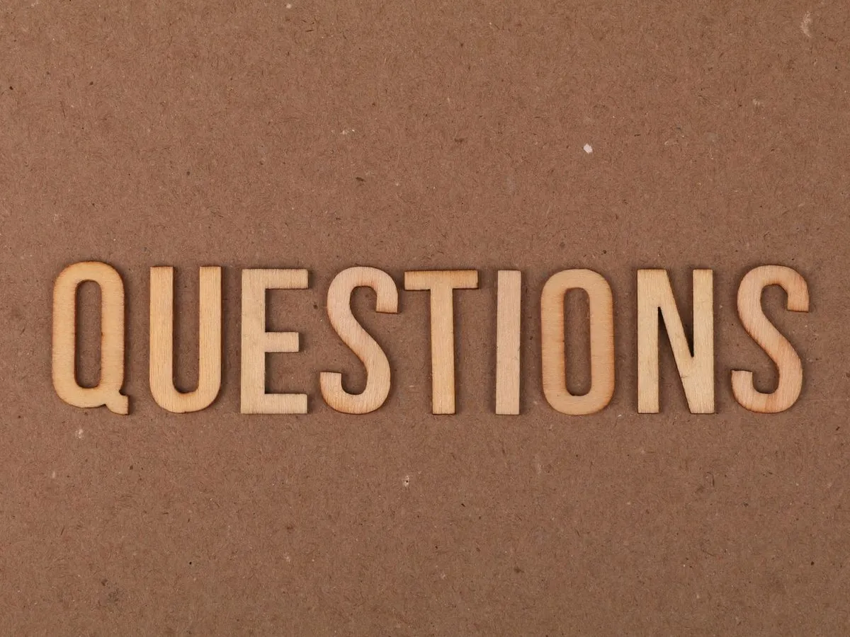 The word QUESTIONS in wooden letters