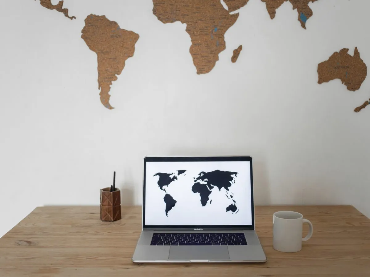 Desk with a laptop showing a world map