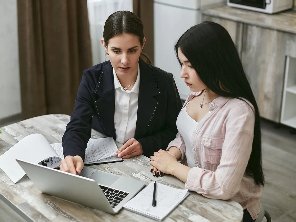 Two colleagues reviewing a plan together on a laptop